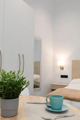 a table with a blue coffee cup and a plant at Apartamento 2º nuevo 400 mt al mar in Valencia