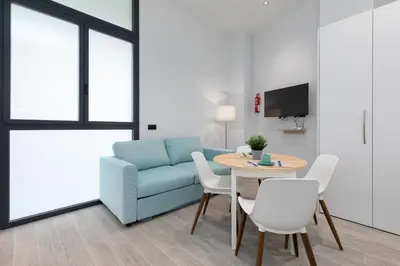 a living room with a blue couch and a table and chairs at Apartamento 2º nuevo 400 mt al mar in Valencia