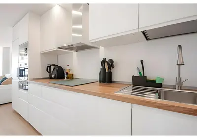 a kitchen with white cabinets and a wooden counter top at El Retiro - Frontal al mar, 1a Línea, como en tu casa in Cullera