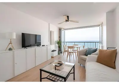 a kitchen with white cabinets and a wooden counter top at El Retiro - Frontal al mar, 1a Línea, como en tu casa in Cullera