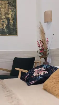 a bed with a pillow and a vase with flowers on it at Las Artes Luxury Double Room in Valencia