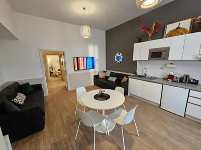 a kitchen and a living room with a table and chairs at Las Artes Luxury Double Room in Valencia