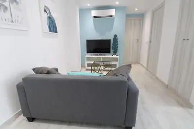 a living room with a gray couch and a tv at Vacansis Apartamento Malvarrosa in Valencia