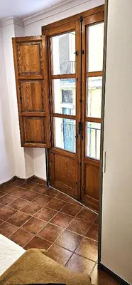 a room with a large wooden door and windows at Vacansis Plaza de la Reina in Valencia