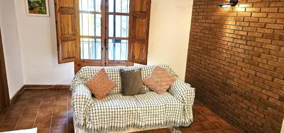 a living room with a couch and a brick wall at Vacansis Plaza de la Reina in Valencia