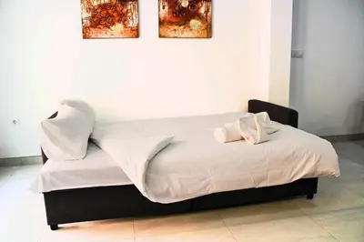 a bed with white sheets and two towels on it at Vacansis Bajo Loft Plus Ultra in Valencia