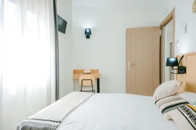 a bedroom with a bed and a window and a chair at BLUESEA Faro Cullera in Cullera