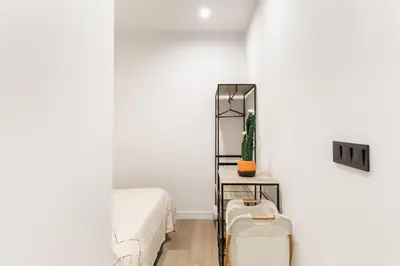 a white room with a bed and a mirror at Turía Flats by Nomad Host in Valencia