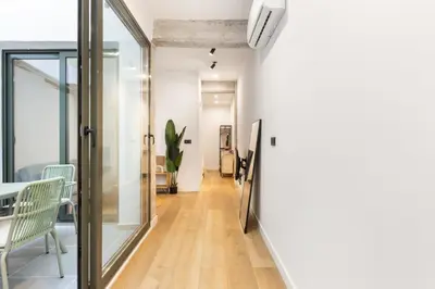 a hallway with glass doors and a table and chairs at Turía Flats by Nomad Host in Valencia