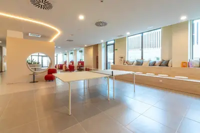 a lobby with a table and chairs in a building at NIDO Malvarrosa Hotel - Apartamento in Valencia