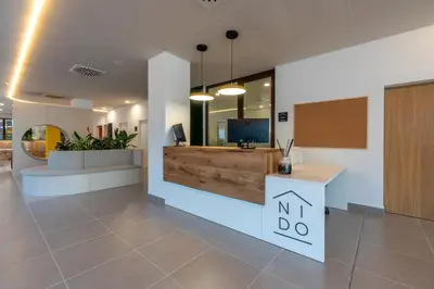 an office lobby with a reception desk and a tv at NIDO Malvarrosa Hotel - Apartamento in Valencia