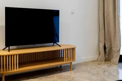 a flat screen tv sitting on top of a wooden stand at VLC Host - Tamarit in Valencia