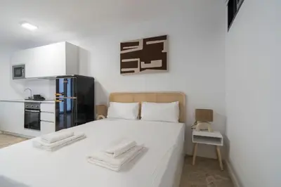 a bedroom with a white bed with towels on it at VLC Host - Tamarit in Valencia