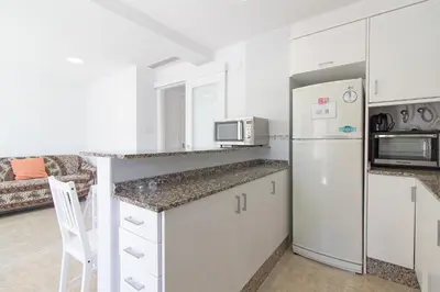 a kitchen with white cabinets and a refrigerator at Global Vacacional, Apartamento en primera linea de playa en Canet de Berenguer in Canet de Berenguer