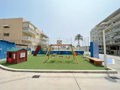 a playground with a slide and a swing at Global Vacacional, Apartamento en primera linea de playa en Canet de Berenguer in Canet de Berenguer