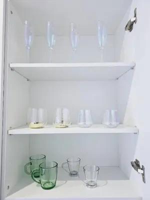 a row of wine glasses and bowls on shelves at Cozy Retreat in Heart of Valencia Perfect for Couples n Families in Valencia