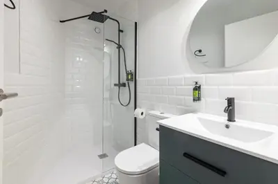 a bathroom with a shower and a toilet and a sink at The Little Village Apartments in Valencia