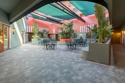 a room with tables and chairs and plants in a building at The Little Village Apartments in Valencia
