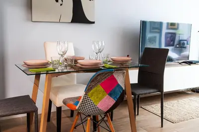 a dining room table with chairs and glasses on it at Cozy Suite next to Plaza del Ayuntamiento in Valencia
