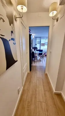 a hallway leading into a living room with a painting on the wall at Cozy Suite next to Plaza del Ayuntamiento in Valencia