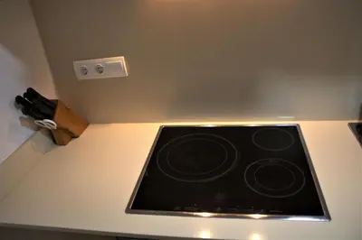 a stove top oven in a kitchen next to a wall at Vacansis Apartamento Florazar 2, 4 in Cullera