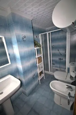 a blue bathroom with a toilet and a sink at Vacansis Apartamento Florazar 2, 4 in Cullera