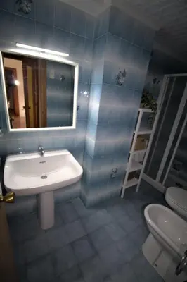a bathroom with a sink and a mirror and a toilet at Vacansis Apartamento Florazar 2, 4 in Cullera