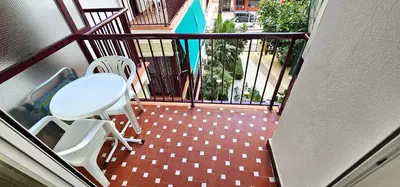a balcony with two white chairs and a table at Vacansis Apartamento Cullera Mar in Cullera