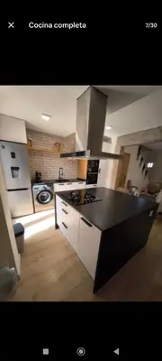 a kitchen with a black and white counter top at Casa con piscina junto al mar in El Perellonet