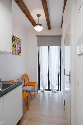 a kitchen with white walls and wooden floors at Colomer Silence in Valencia