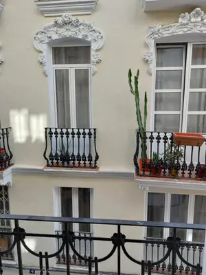 a white building with two windows and a fence at Colomer Silence in Valencia
