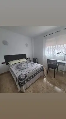 a kitchen with white cabinets and a blue floor at Room with private bathroom in Alfara del Patriarca