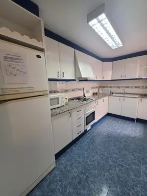 a kitchen with white cabinets and a refrigerator at Room with private bathroom in Alfara del Patriarca