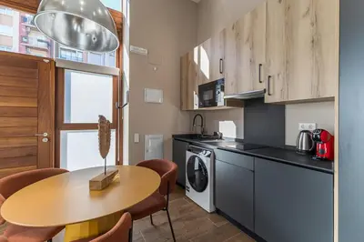 a kitchen with a table and a sink and a dishwasher at Suite Premium junto al Río Turia 1 in Valencia