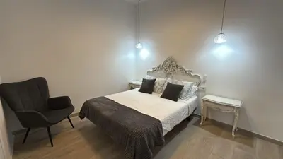 a bedroom with a bed and a chair at Salabert Suite in Valencia