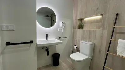 a bathroom with a toilet and a sink and a mirror at Salabert Suite in Valencia