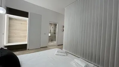 a white room with a bed and a window at Salabert Suite in Valencia