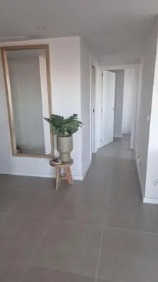 a hallway with a potted plant in a white room at Appartement avec vue piscine in Canet de Berenguer