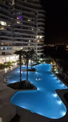 a large building with blue lights on the side of it at Appartement avec vue piscine in Canet de Berenguer