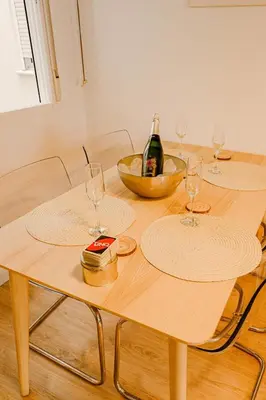 a wooden table with two glasses and a bottle of wine at Cabanal Beach House - 10 min to ocean , FastWifi , SmartTV, AC in Valencia