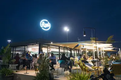 a group of people sitting at a restaurant at night at Cabanal Beach House - 10 min to ocean , FastWifi , SmartTV, AC in Valencia