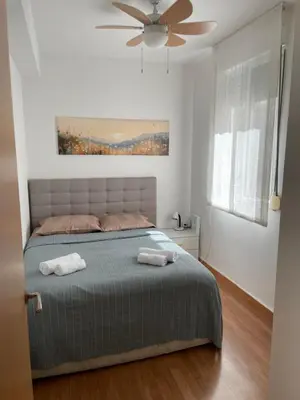 a bedroom with a bed and a ceiling fan at Valencia Apartamento Sol de Naranja in Sueca