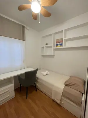 a bedroom with a bed and a desk and a ceiling fan at Valencia Apartamento Sol de Naranja in Sueca