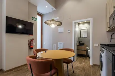 a kitchen with a table and chairs in a room at Premium Suite by the Turia River 3 in Valencia