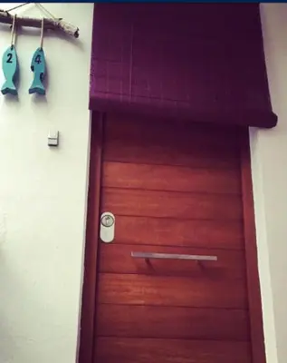 a wooden door in a room with two hooks at La Calita del Versalles in Faro de Cullera