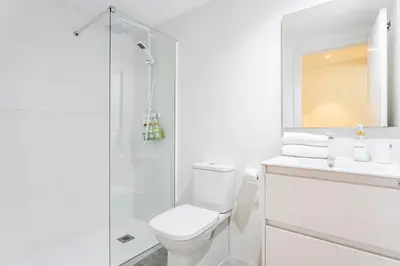 a white bathroom with a toilet and a shower at BiS Suites Ruzafa in Valencia