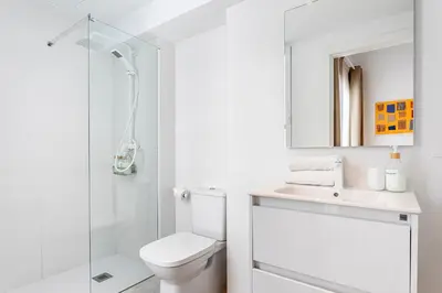 a white bathroom with a toilet and a shower at BiS Suites Ruzafa in Valencia