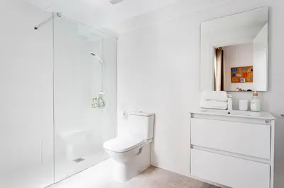 a white bathroom with a toilet and a shower at BiS Suites Ruzafa in Valencia
