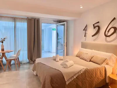 a bedroom with a large bed in a room with a table at BiS Suites Ruzafa in Valencia
