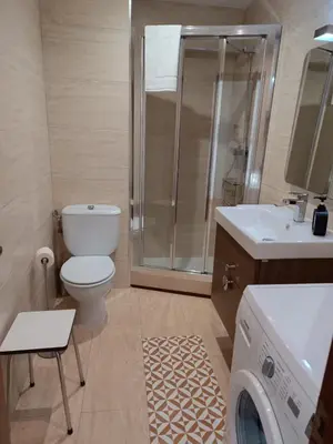 a bathroom with a toilet and a sink and a washing machine at Fleming's Beach in Puebla de Farnals